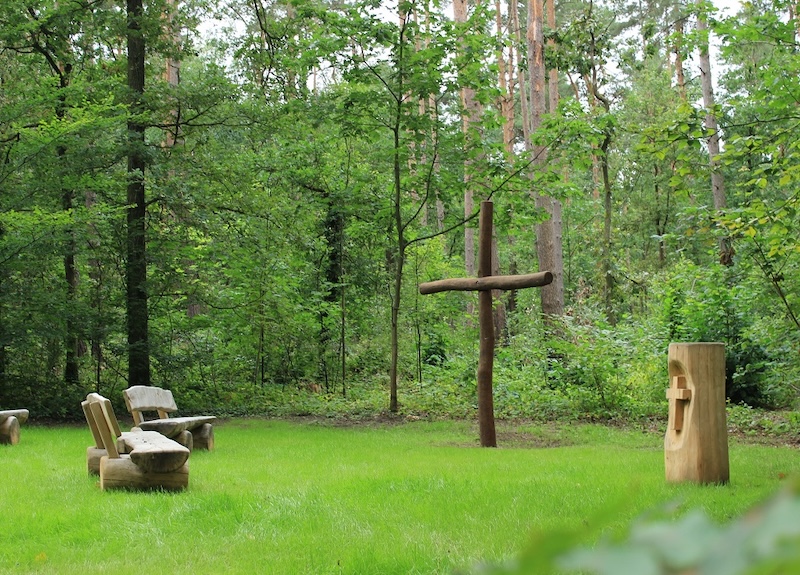 Andachtsplatz im RuheForst Waldhufe mit Kreuz, Urnenstele und Sitzbänken aus Holz
