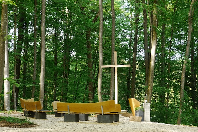 Andachtsplatz im RuheForst Weidenstetten mit Holzkreuz, Urnenstele, Rednerpult und Sitzbänken