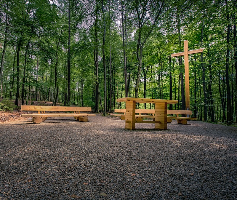 Andachtsplatz im Waldfriedhof Erzgebirge mit Sitzbänken, Tisch und einem Holzkreuz