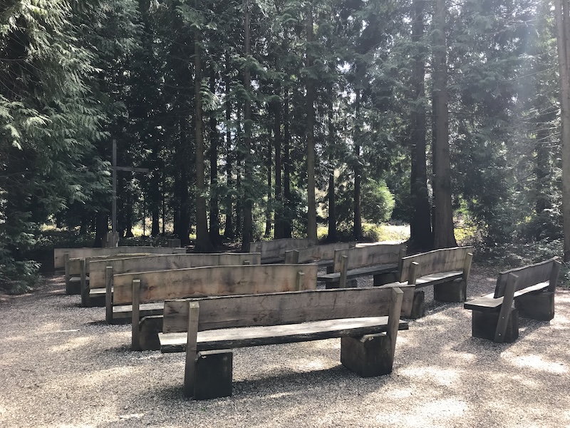 Andachtsplatz mit Holzkreuz und zahlreichen Sitzbänken aus Holz in der Waldruhestätte Meerbusch